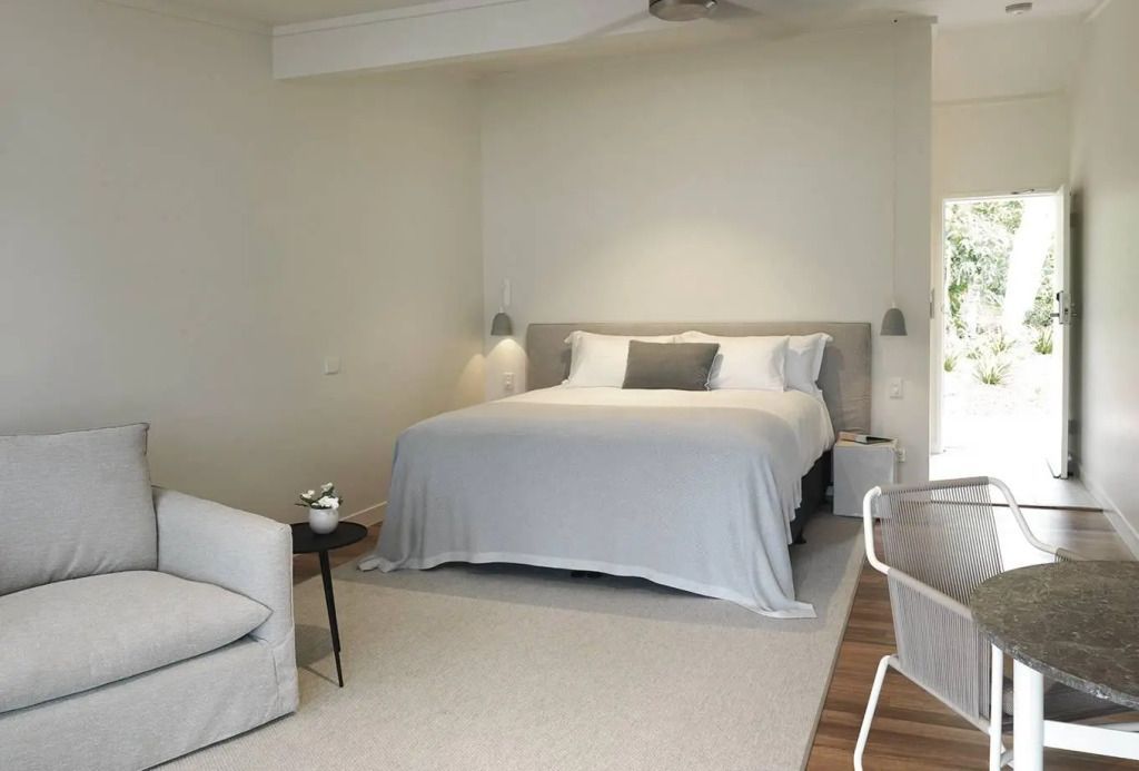 Modernes Doppelzimmer mit heller Einrichtung und Balkon