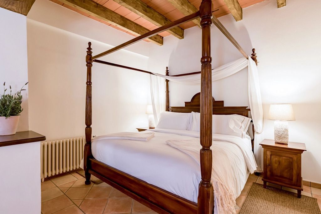 Einladendes Himmelbett unter freiliegenden Holzbalken