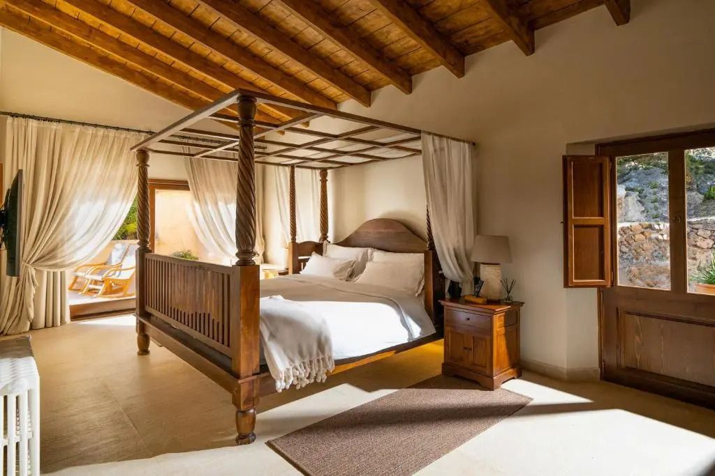 Vierpfostenbett aus Holz in einem hellen Schlafzimmer