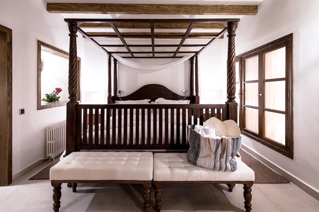 Himmelbett mit Holzbalken und Sitzbank im luxuriösen Schlafzimmer