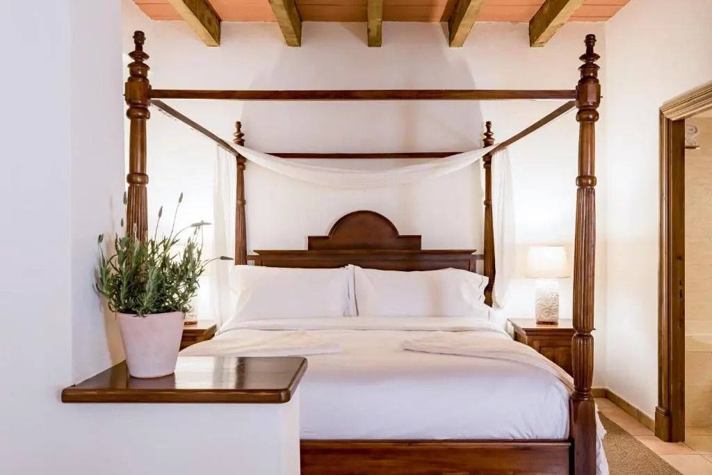 Elegantes Himmelbett mit weißen Laken im Superior Doppel Zimmer.