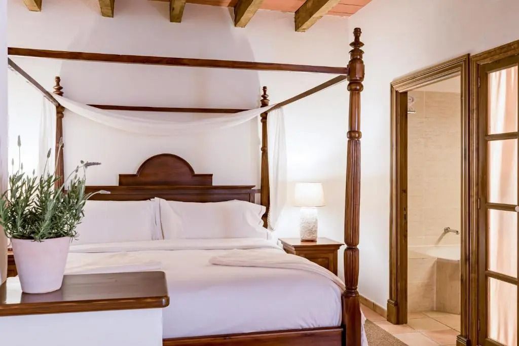 Himmelbett im Zimmer mit Sicht auf Badezimmer Eingang.