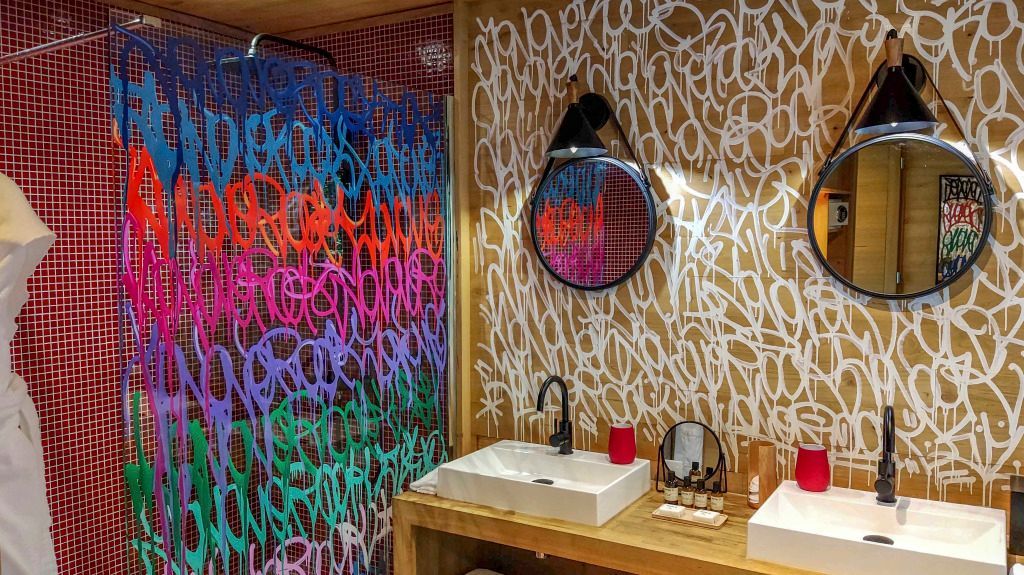 Modernes Badezimmer mit auffälligem buntem Graffiti und stilvollem Waschbecken