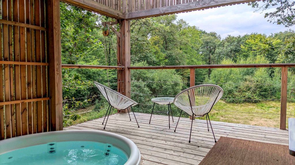 Wunderschöne Terrasse mit Jacuzzibad, Blick in die grüne Natur und stilvollen Sitzmöbeln