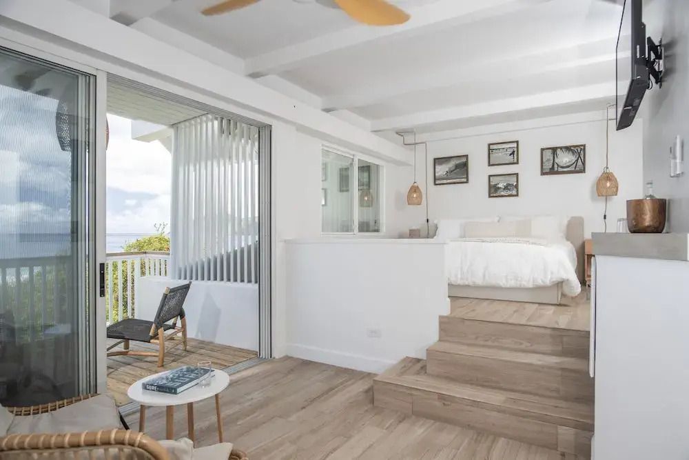Helles Standardzimmer mit offenem Wohnbereich und Zugang zur Terrasse im Long Bay Beach Resort