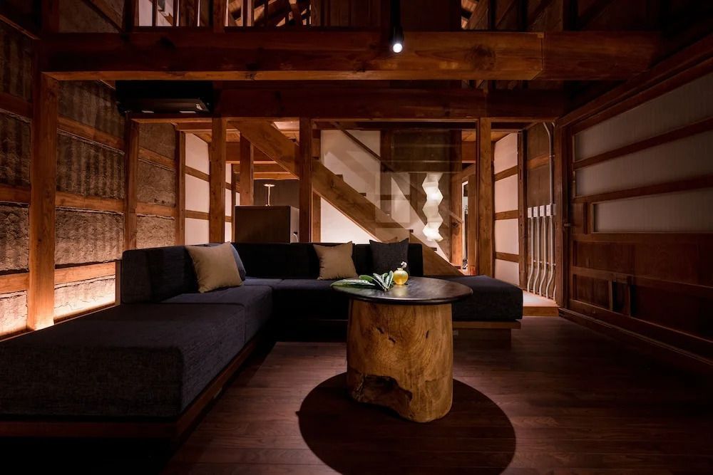 Gemütlicher Wohnbereich mit Holzwänden und stilvollem Möbelstück im Loquat Nishi Izu Hotel.