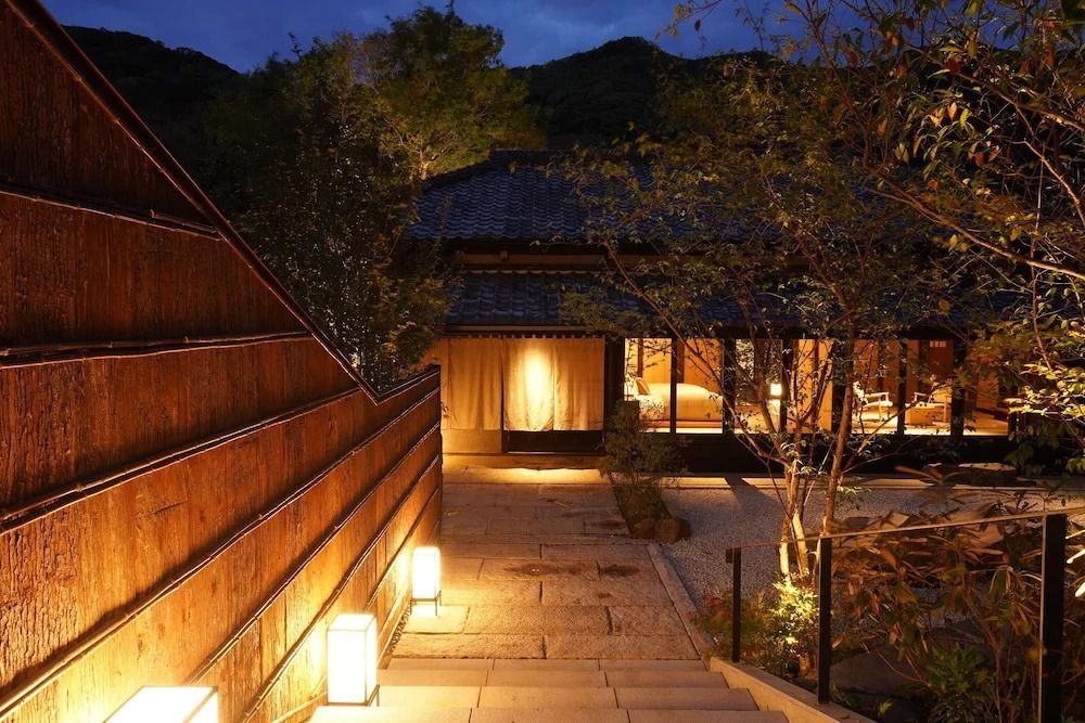 Abendaufnahme eines beleuchteten Eingangs mit traditionellem japanischen Dach