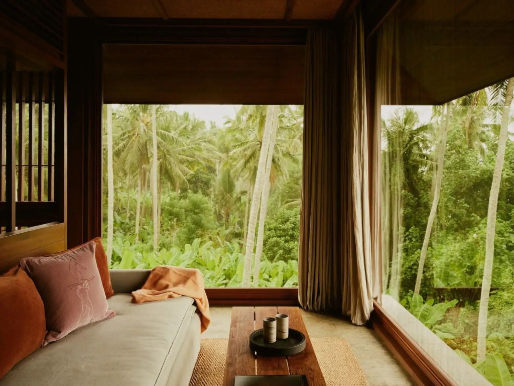 Lounge-Bereich mit Blick auf tropische Vegetation und großen Fenstern
