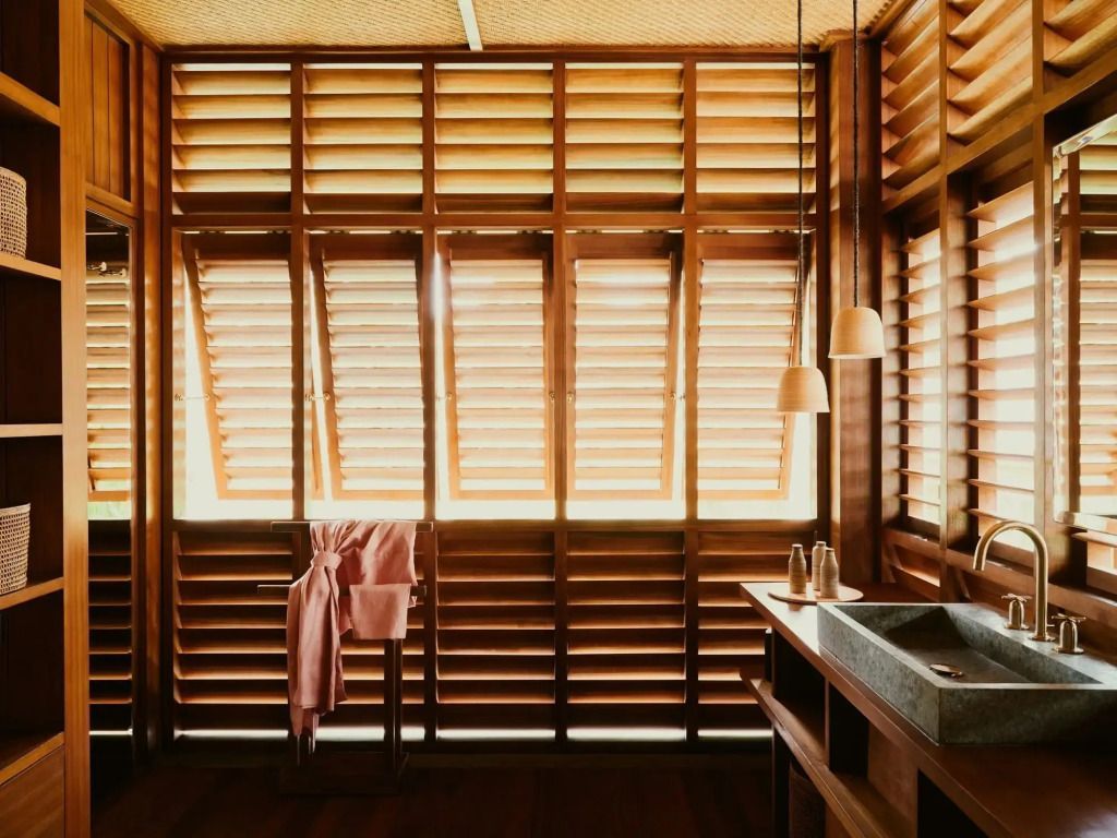 Luxuriöses Badezimmer mit Lamellenfenstern und Naturmaterialien