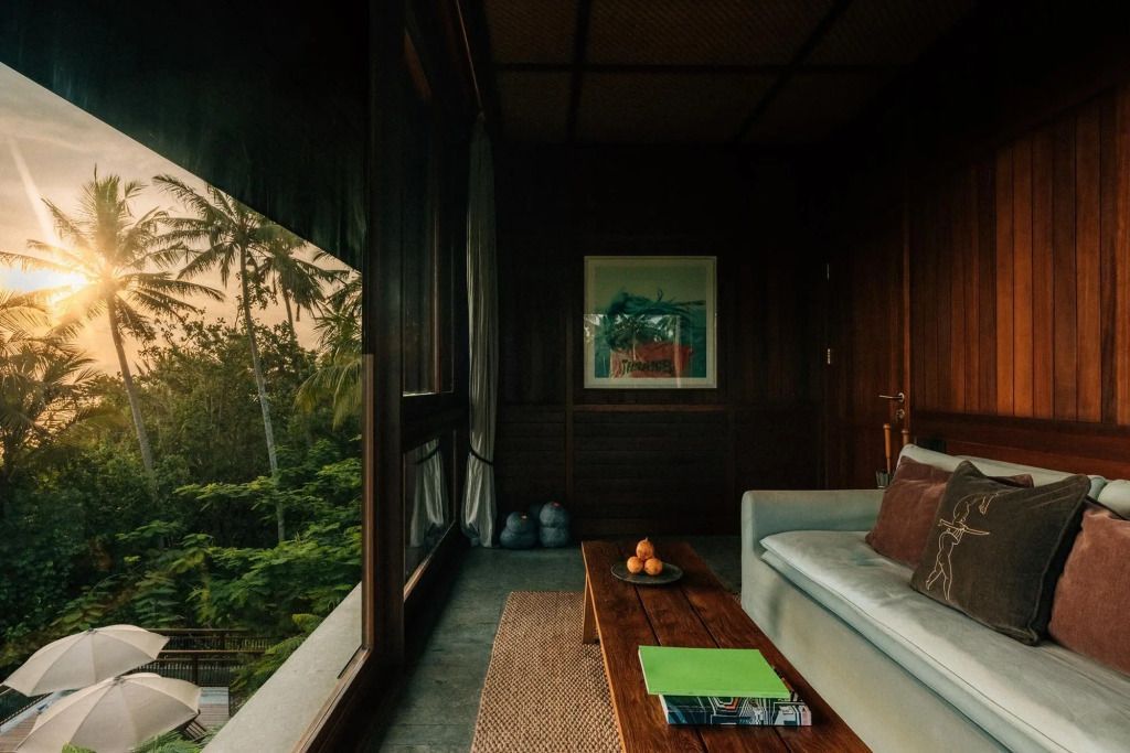 Gemütliche Sitzecke mit einem Tisch, Fensterblick auf tropische Vegetation.