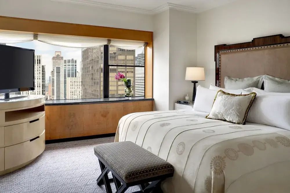 Gemütliches Schlafzimmer mit großem Bett und Stadtblick in der Executive Towers Suite