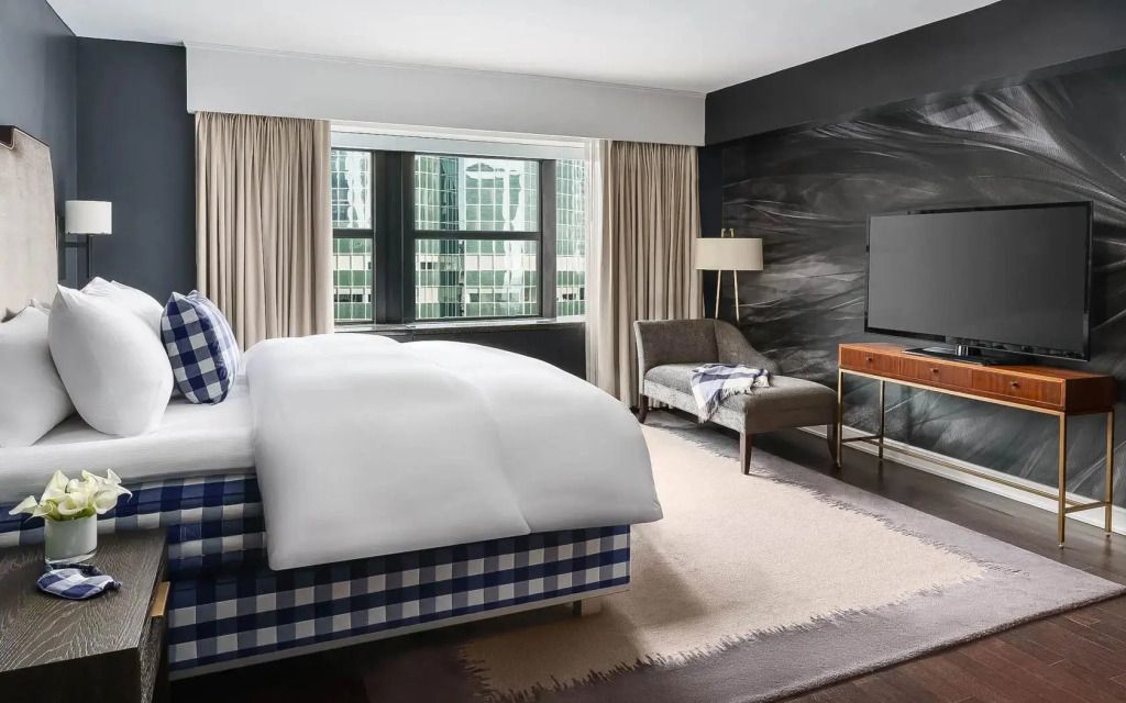 Hästens Ultimate Sleep Suite mit Ausblick auf Gebäude und entspannter Leseecke.