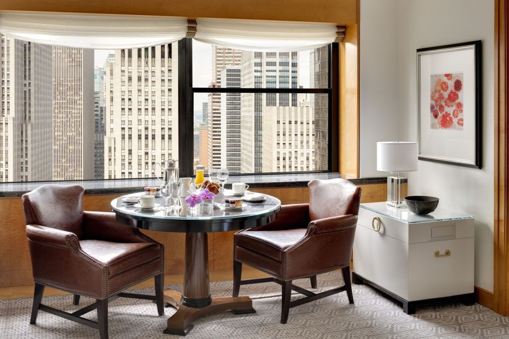 Elegante Sitzecke im Hotelzimmer mit Aussicht auf New Yorker Hochhäuser.