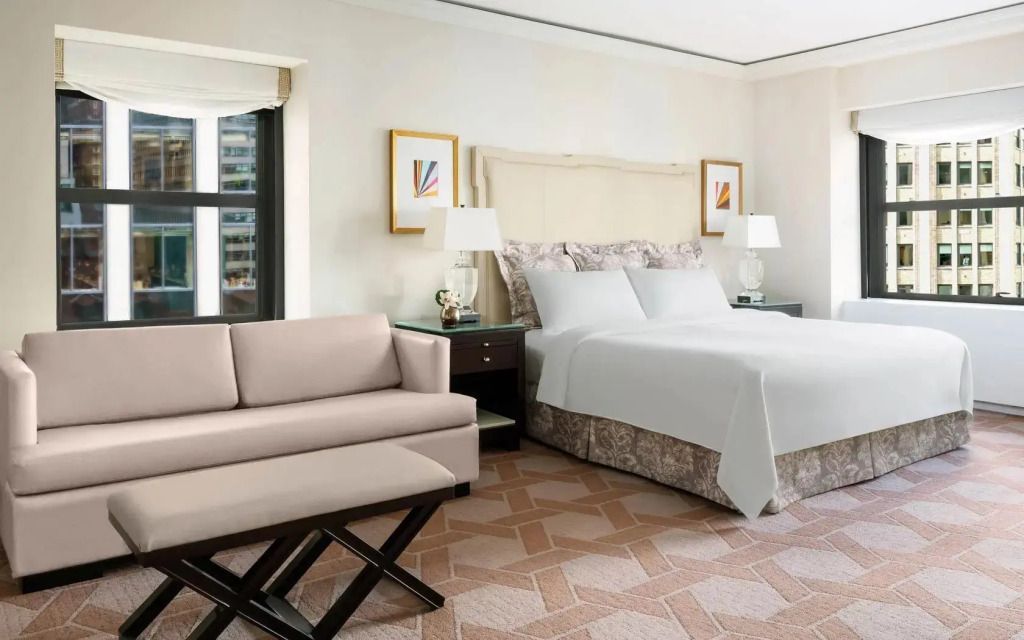 Ein Zimmer mit großem Bett, Sofa, Nachttischen und moderner Dekoration