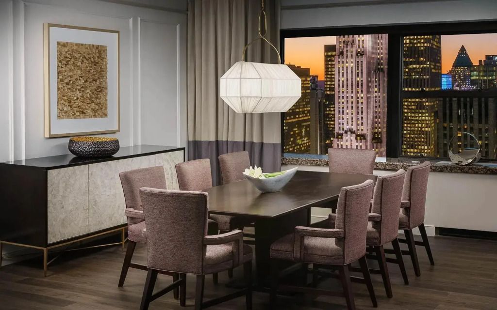 Eleganter Essbereich in der Skyview Suite mit Blick auf die Stadt bei Sonnenuntergang.