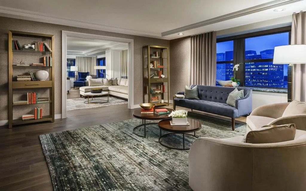 Geräumiges Wohnzimmer der Skyview Suite mit moderner Einrichtung und Stadtblick.