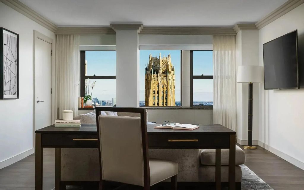 Suite-Schreibtisch mit Blick aufs Fenster und ikonisches Gebäude im Hintergrund