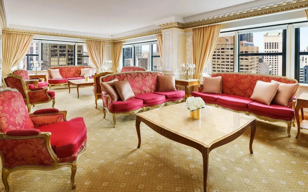 Helles und luxuriöses Wohnzimmer mit roten Sofas und großen Fenstern im Imperial Suite