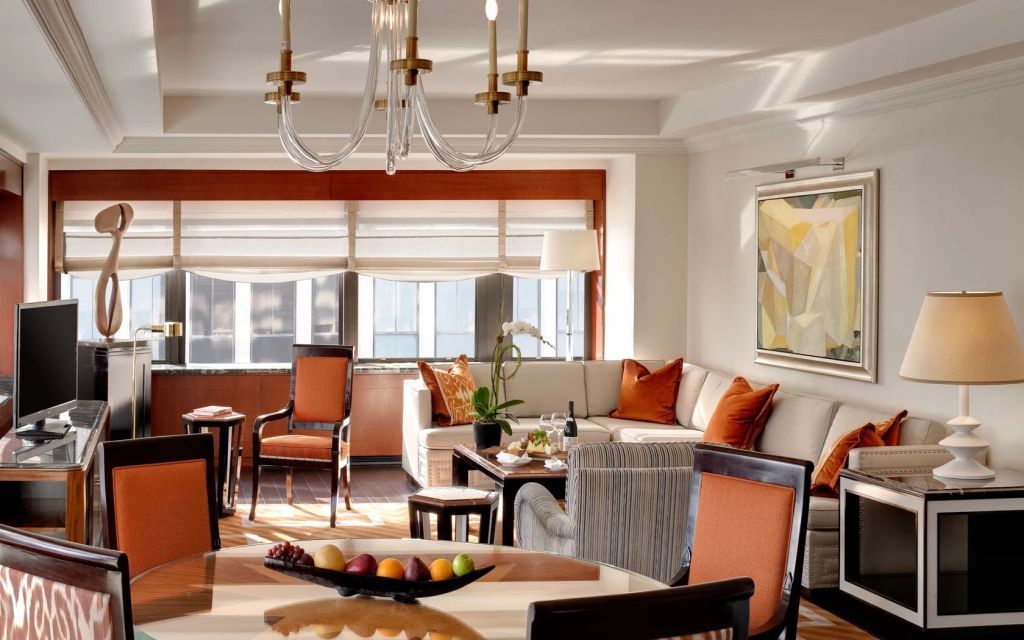 Heller Wohnbereich mit eleganten Möbeln und Kronleuchter im Lotte New York Palace.