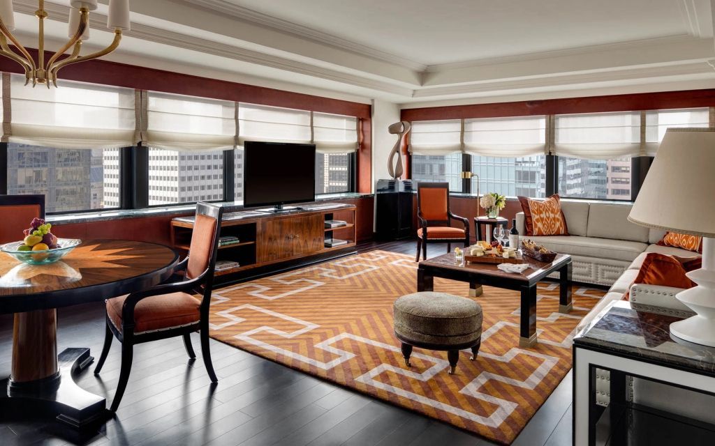 Geräumiges Wohnzimmer mit stilvollem Teppich und großen Fenstern im Lotte New York Palace.