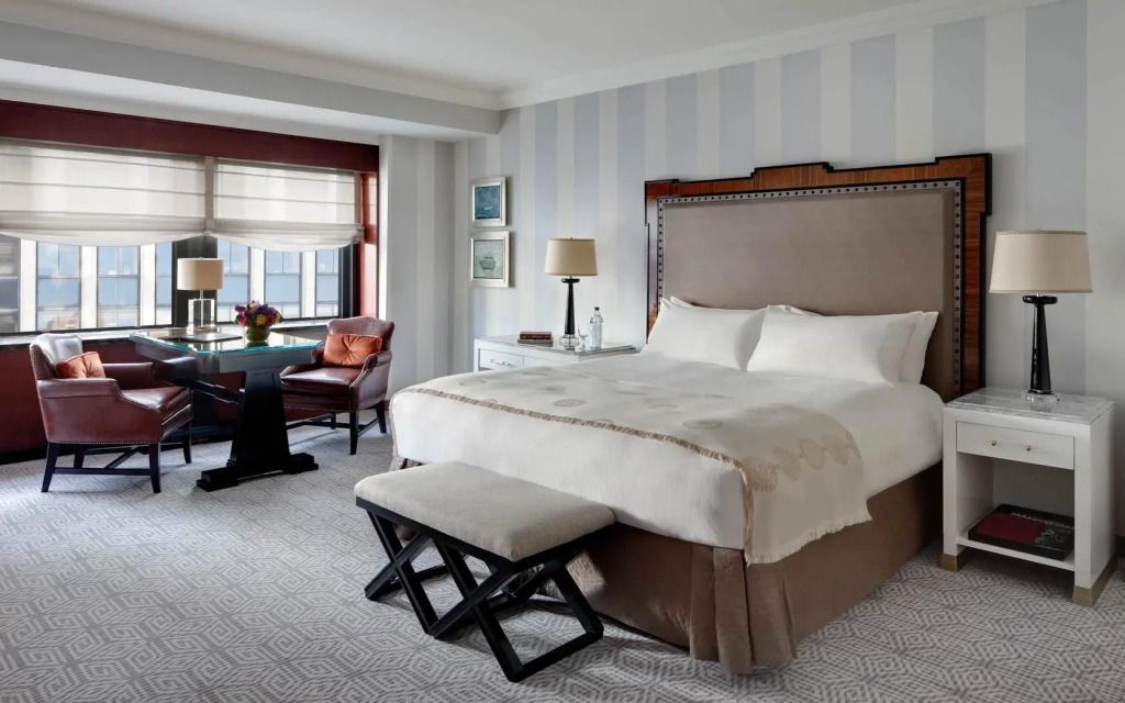 Luxuriöses Schlafzimmer im Lotte New York Palace mit Kingsize-Bett und elegantem Dekor.