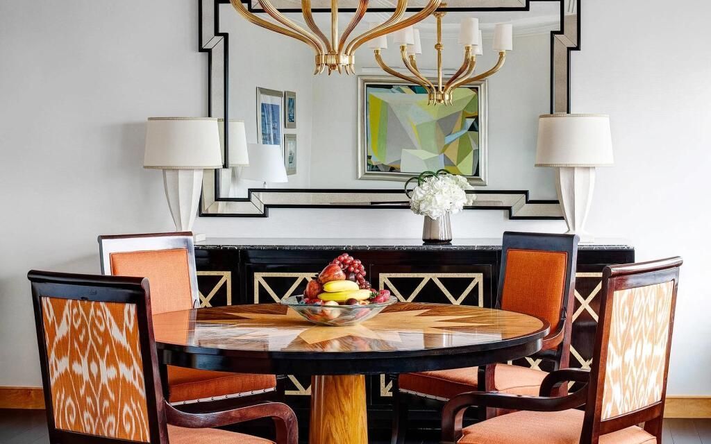 Eleganter Essbereich mit Holz-Tisch und leuchtendem Kronleuchter im Lotte New York Palace.