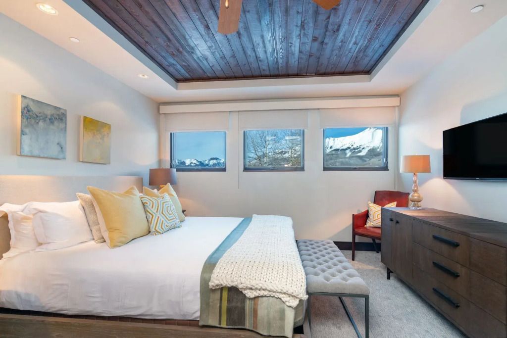 Schlafzimmer mit großem Fenster, natürlicher Beleuchtung und Sicht auf die Berge.