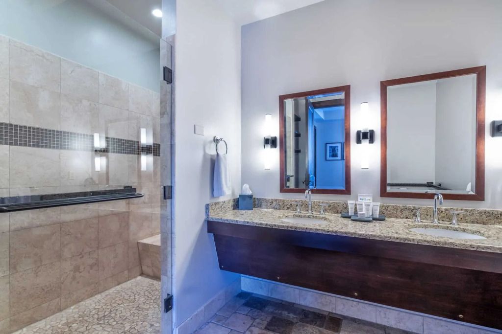 Badezimmer mit Doppelwaschbecken und geräumiger Dusche
