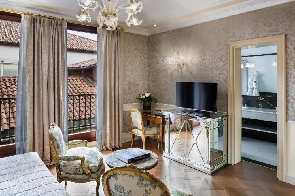 Wohnbereich mit stilvollen Sesseln, Flachbildfernseher und elegantem Lichtdesign.