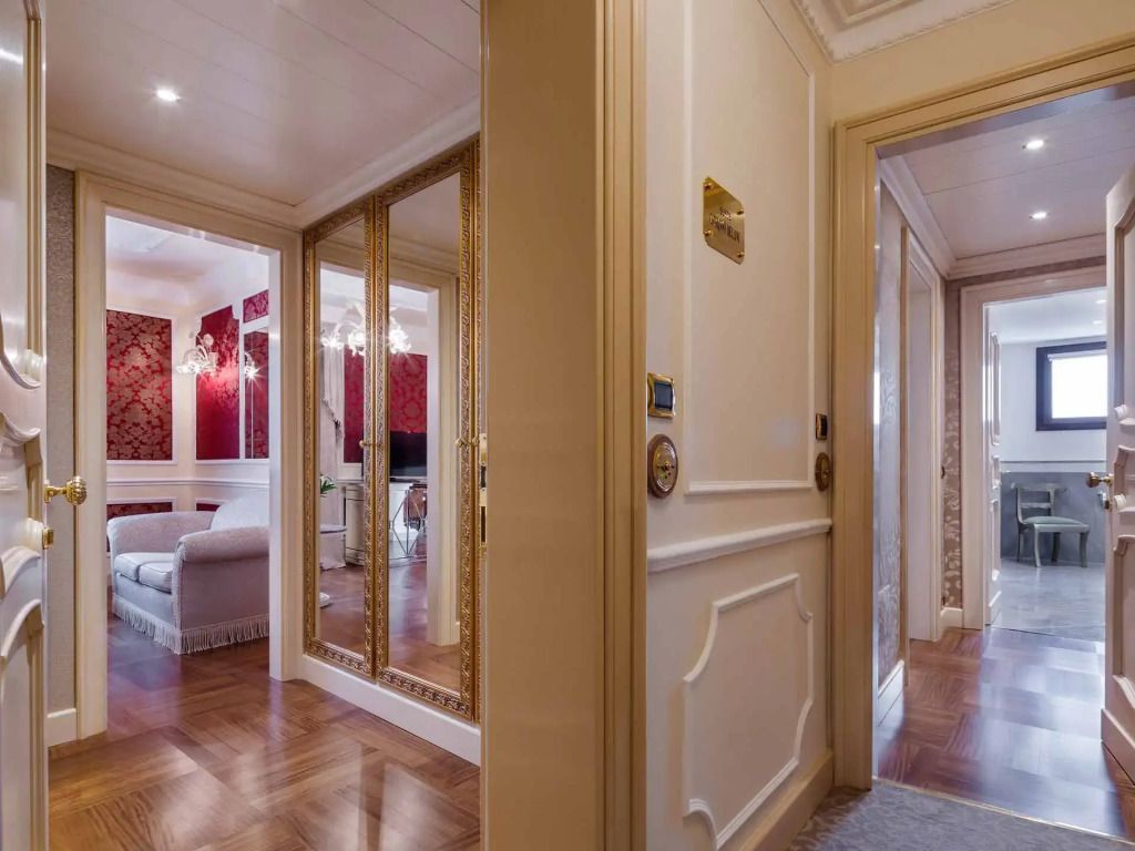 Eleganter Eingangsbereich der Suite mit Spiegeln und stilvollen Verzierungen