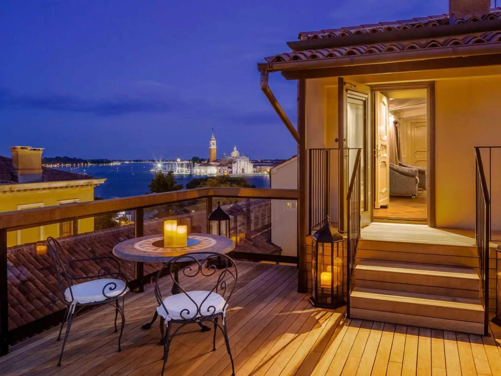 Beleuchtete Terrasse bei Nacht mit romantischer Aussicht auf Venedig