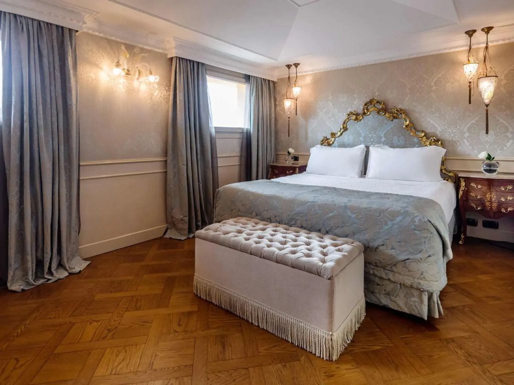 Elegantes Schlafzimmer der Goldoni Familie Suite mit luxuriösem Doppelbett und Parkettboden