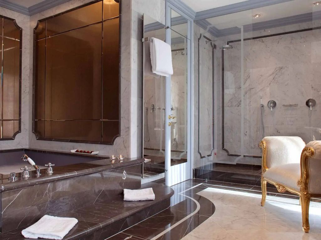 Luxuriöses Badezimmer in Marmor mit großem Whirlpool und eleganten Details.