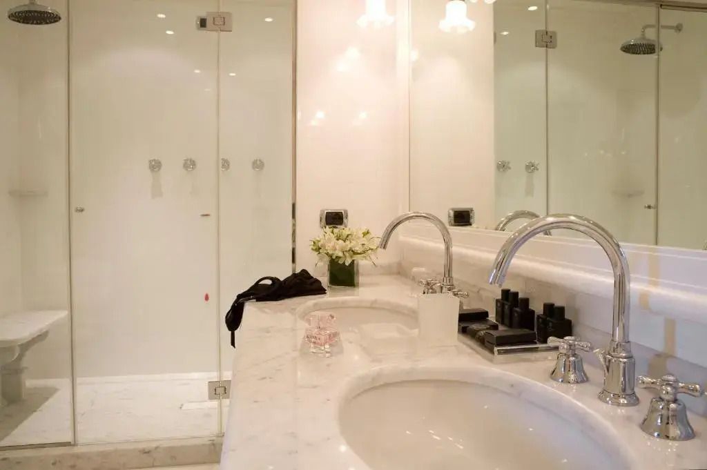 Modernes Badezimmer mit weißen Marmoroberflächen und eleganter Beleuchtung
