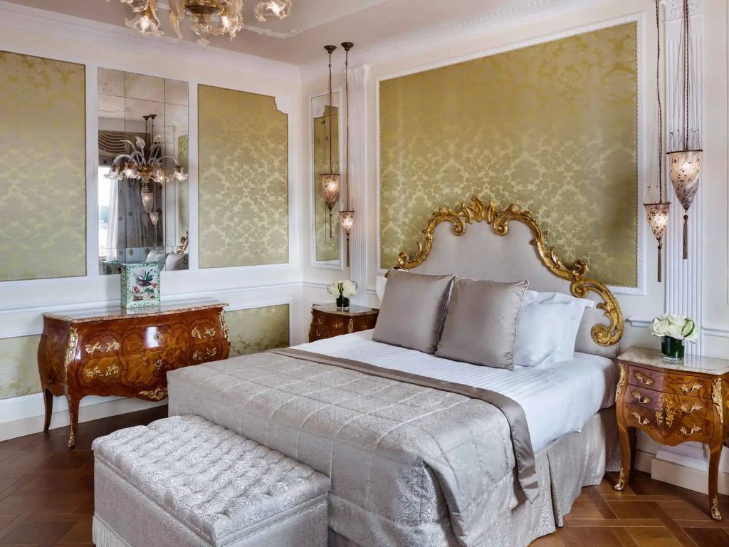 Elegantes Schlafzimmer mit vergoldetem Kopfteil und luxuriöser Tapete
