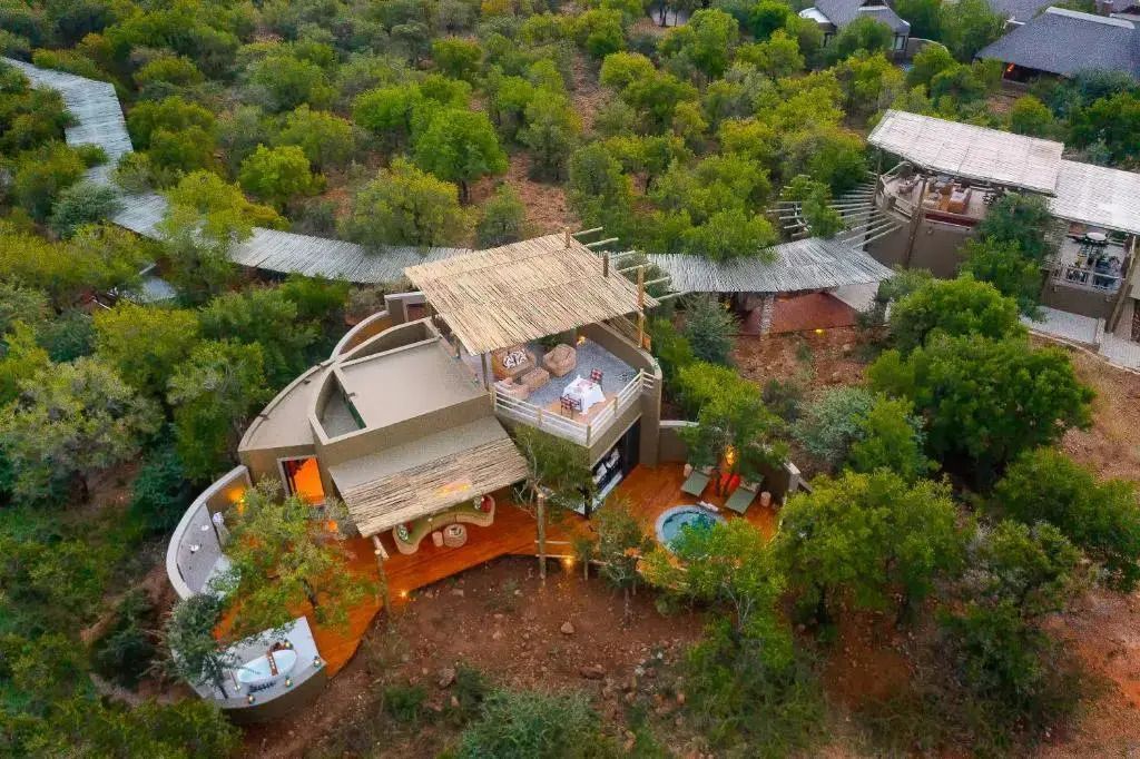Luftaufnahme der Lodge inmitten üppiger Vegetation mit Dachterrasse und Pool