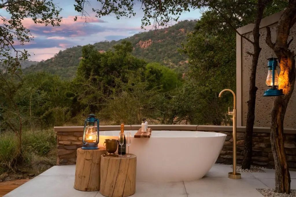 Freistehende Badewanne auf Terrasse mit Naturblick im Abendlicht