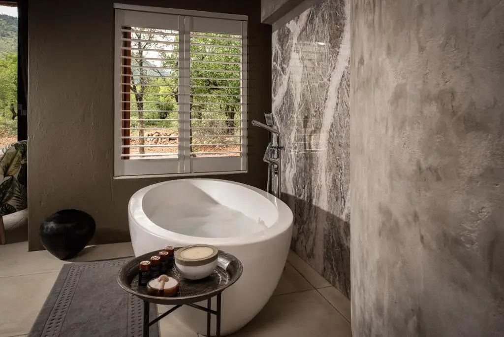 Elegantes Badezimmer mit freistehender Badewanne und Blick ins Grüne