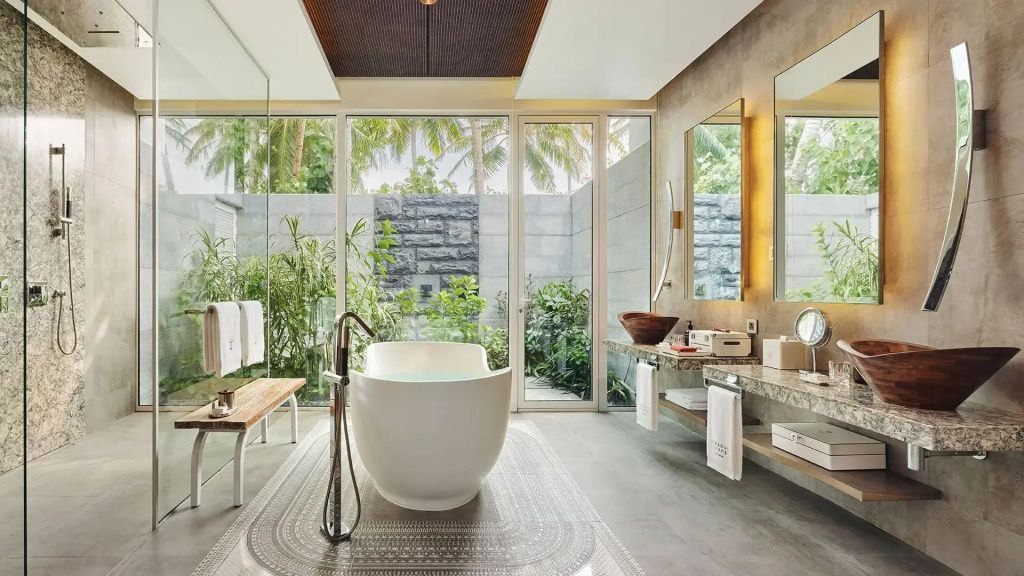 Luxuriöses Badezimmer mit freistehender Badewanne und tropischen Pflanzen