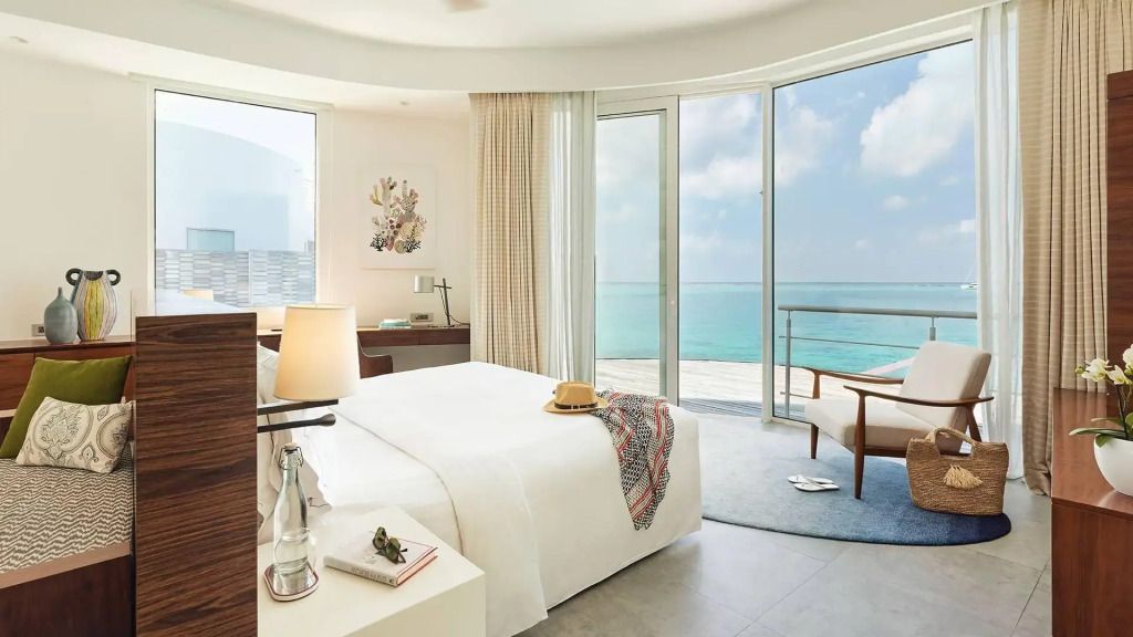 Helles Schlafzimmer mit großem Fenster und Meerblick in einer Villa auf den Malediven