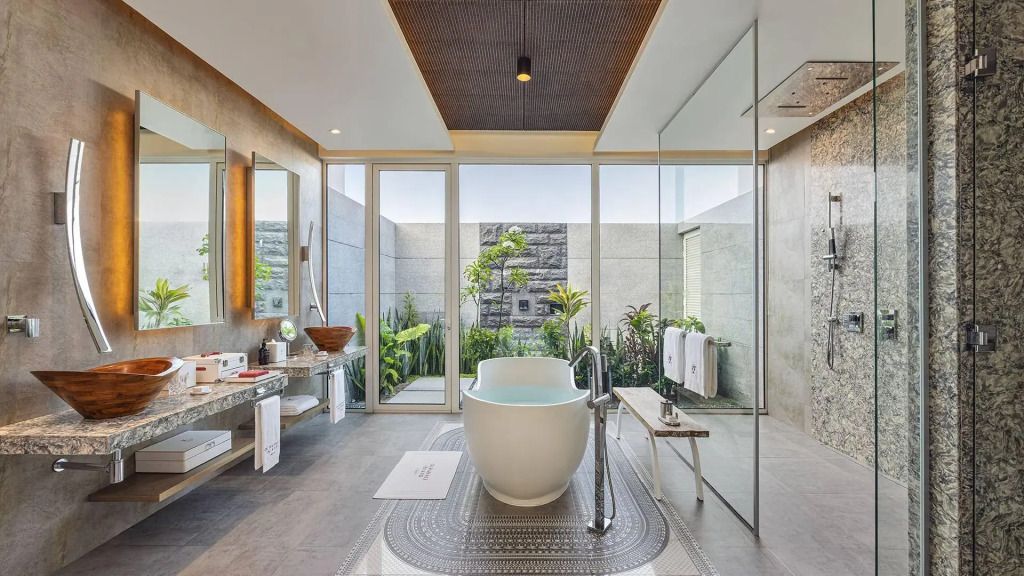 Modernes Badezimmer mit freistehender Badewanne und Pflanzen im Hintergrund