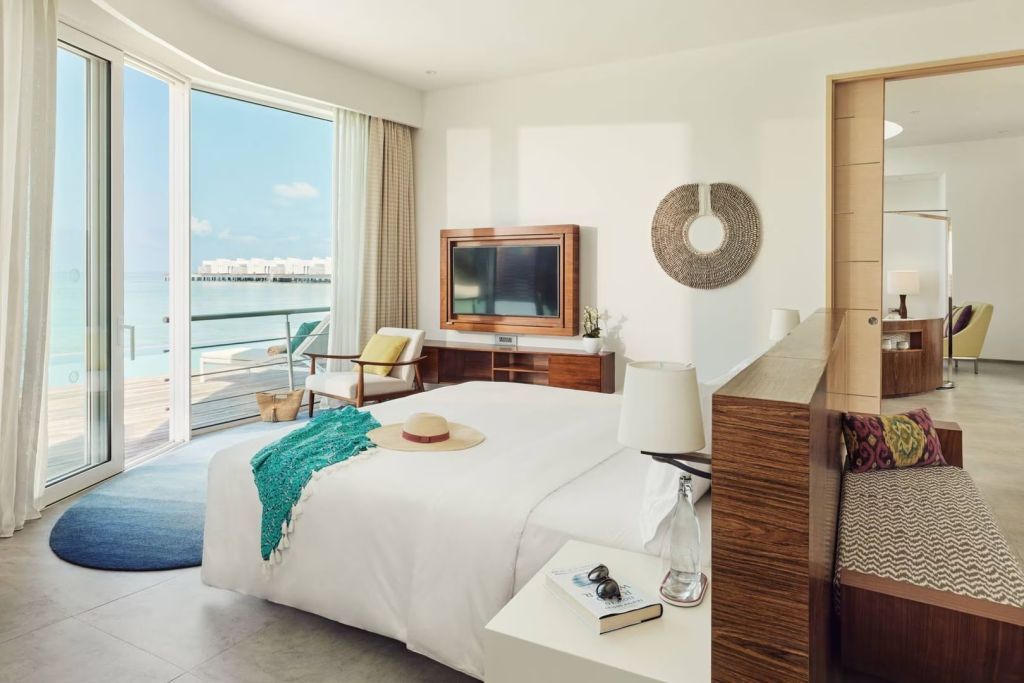 Geräumiges Schlafzimmer einer Wasser Villa mit Doppelbett und Meerblick