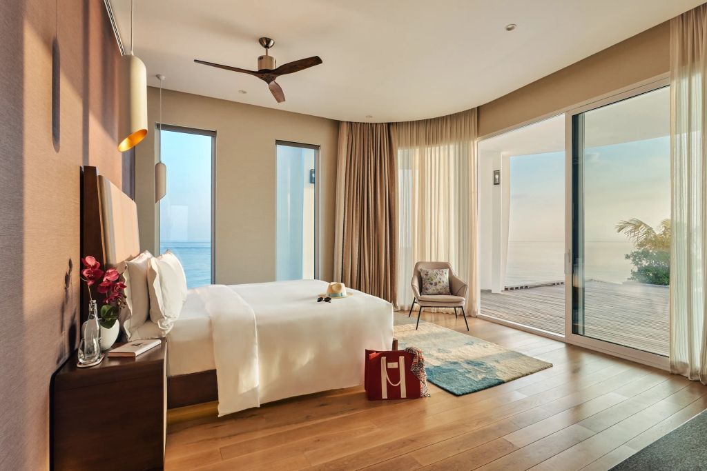 Gemütliches Schlafzimmer mit Holzfußboden und Blick aufs Meer