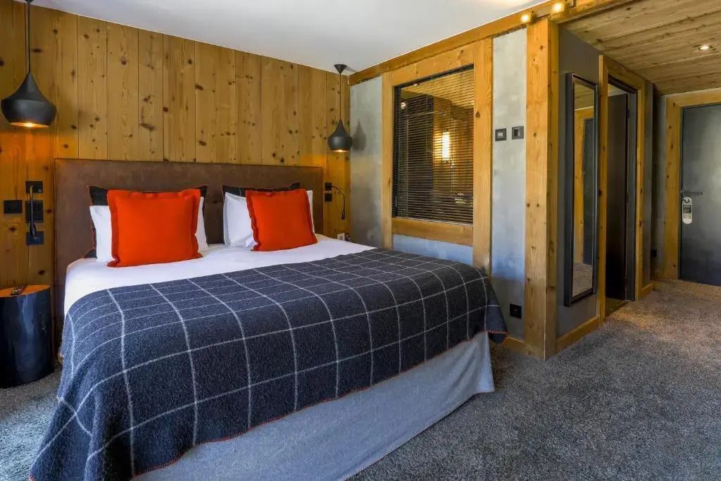 Gemütliches Deluxe Doppelzimmer mit Holzwänden und modernem Design.