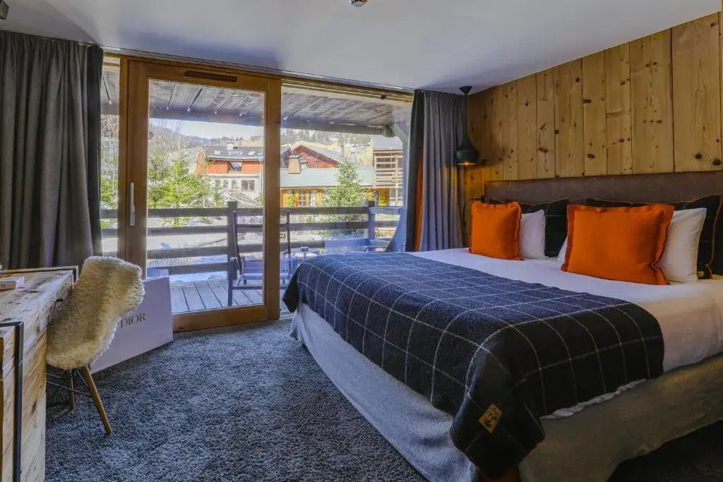 Deluxe Doppelzimmer mit Blick auf Balkon und Berglandschaft.