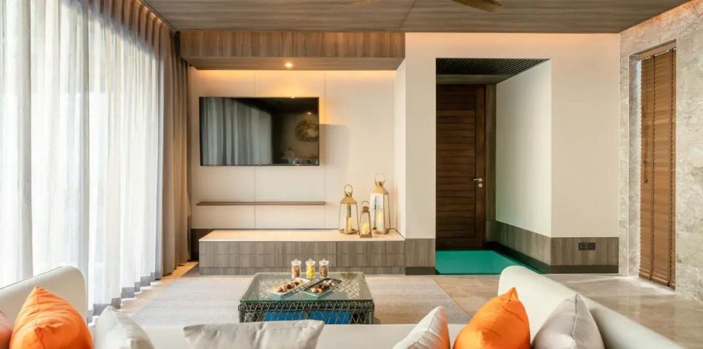 Gemütlicher Wohnbereich mit Fernseher und Dekoration in der Grand Madifushi Aqua Pool Villa