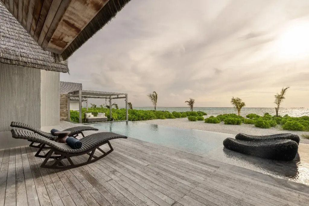 Infinity-Pool mit Blick auf das Meer und näherstehende Sonnenliegen