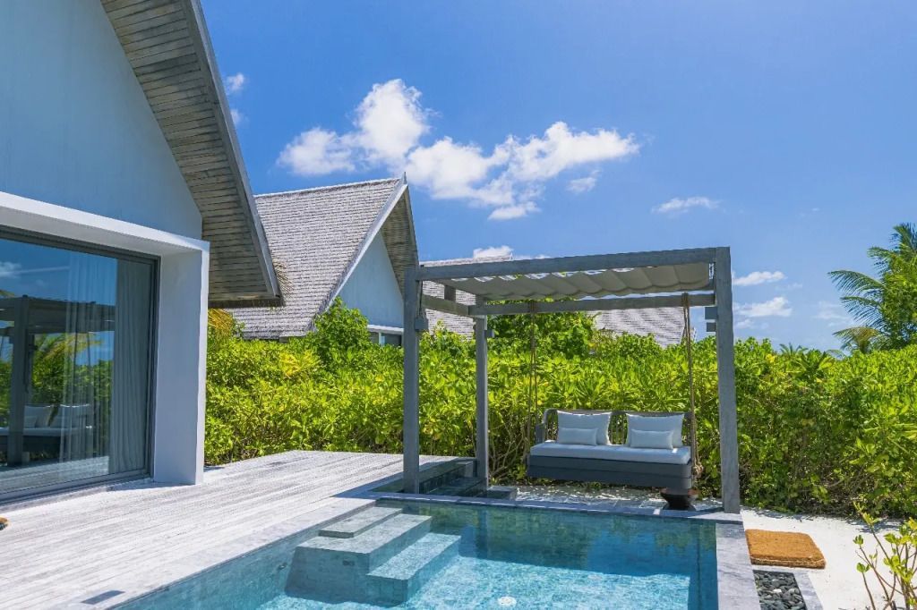 Private Terrasse mit Pool und Himmelbett, umgeben von tropischer Vegetation