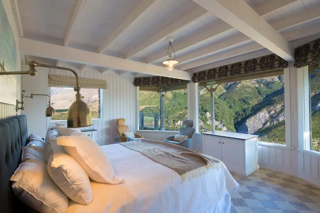 Luxuriöses Schlafzimmer mit großen Fenstern und Bergblick