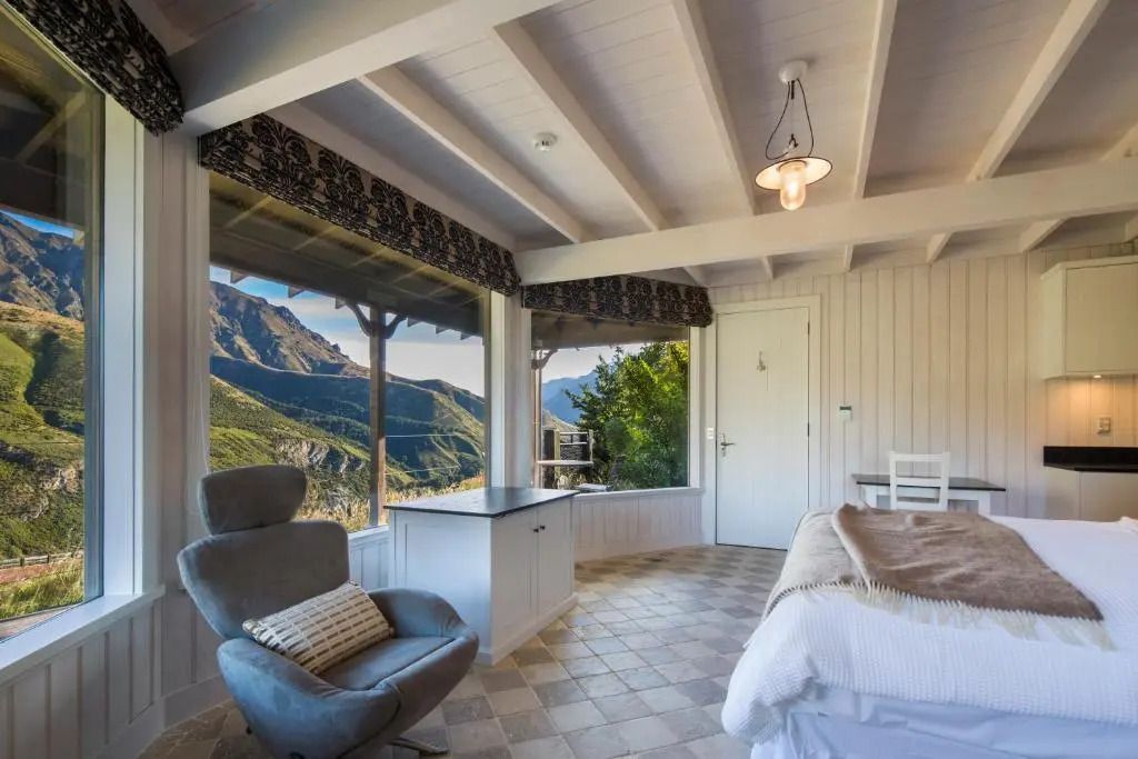 Gemütliches Zimmer mit Sesseln und Bergblick aus großen Fenstern
